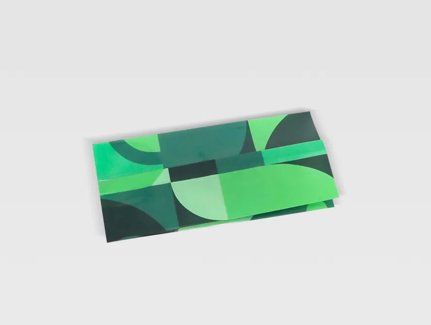 Side view of a flat laying green gusset bag with reflective geometric pattern, flexible packaging style