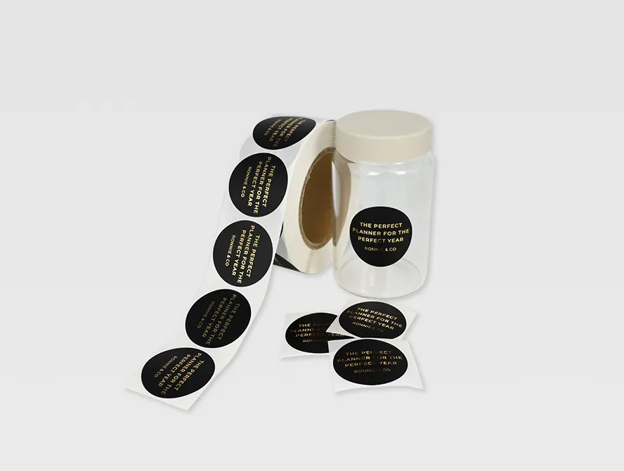 Unrolled custom black labels with gold foil text