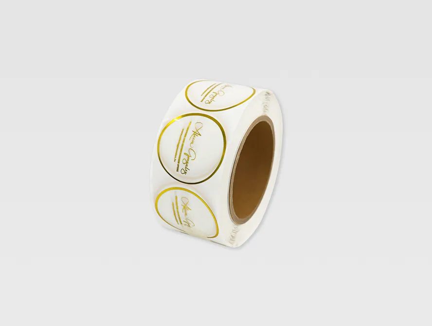 Roll of round transparent labels with gold foil text