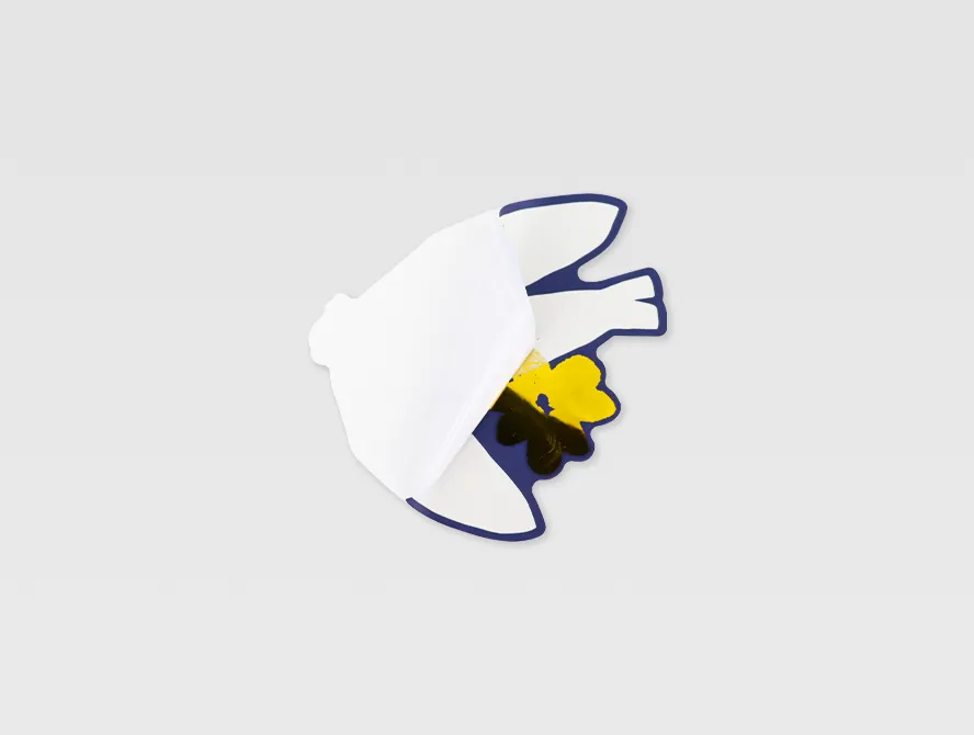 Side view of a gold foil flower sticker slightly peeled