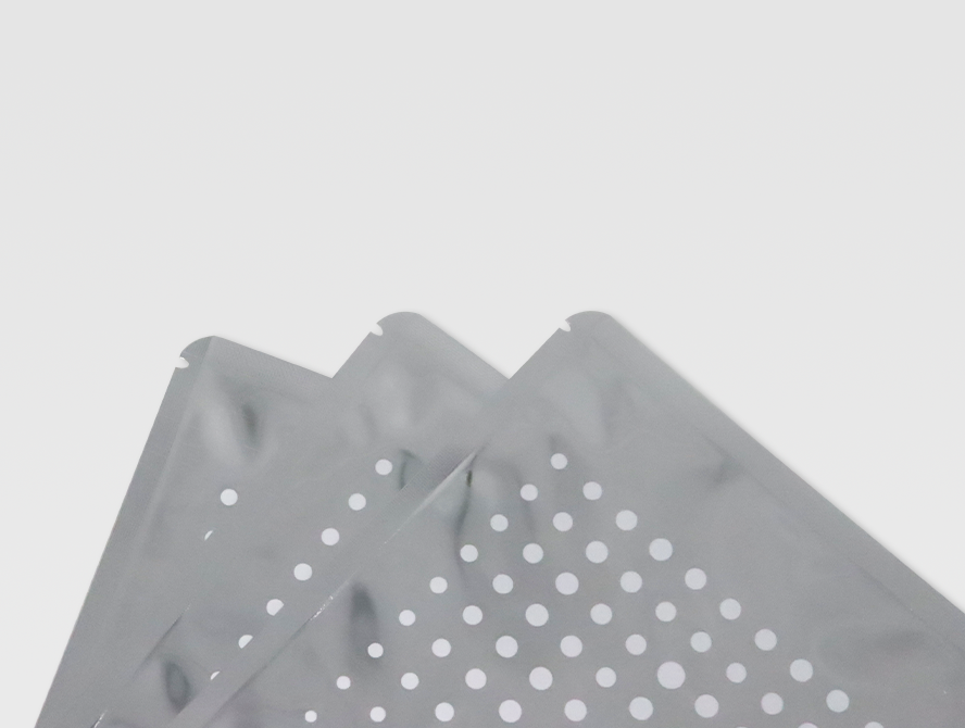 Stack of flat silver foil pouches with perforation pattern on one side