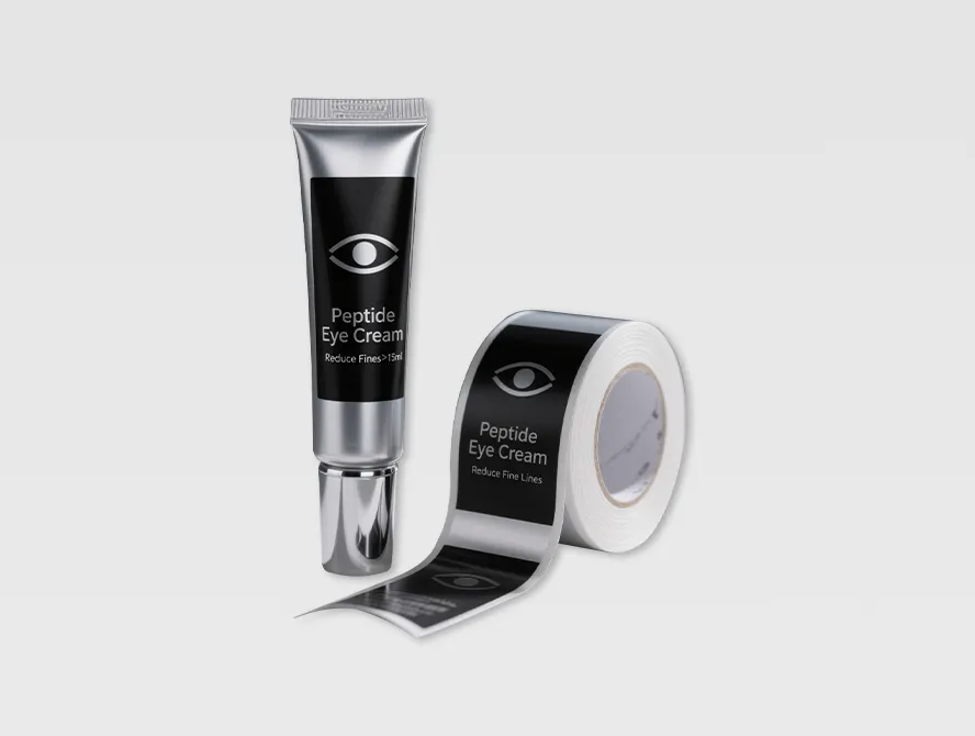 Removable sticker roll next to black cosmetic packaging tube