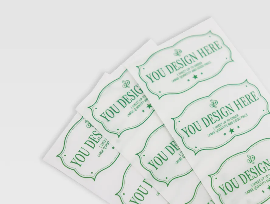Close up view of curved candle label stickers in green print